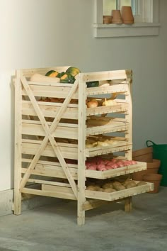 a wooden crate filled with lots of food on top of a cement floor next to a window