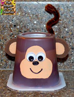 a brown and white cup with a monkey face on it's side sitting on a counter