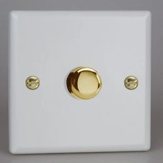 a white and gold light switch with two knobs