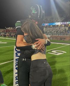 two women embracing each other at a football game