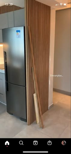 a modern kitchen with stainless steel refrigerator and wood slats