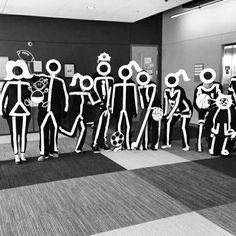 black and white photograph of people dressed up as skeletons in an office hallway with basketballs on the floor