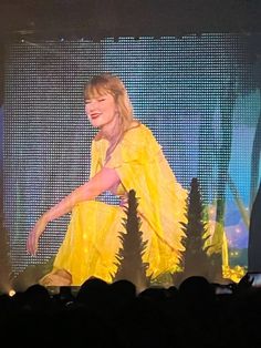 a woman in a yellow dress on stage