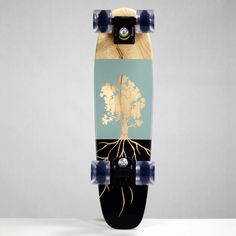 a skateboard with an image of a tree and roots on the bottom, against a gray background