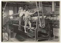 two young boys working on an old machine