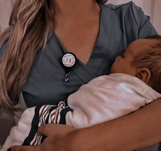 a woman holding a baby in her arms and wearing a watch on it's wrist