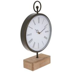 a clock on a wooden stand with roman numerals and a black ring around the face