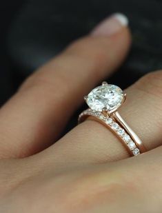 a woman's hand with a diamond ring on her finger and an engagement band