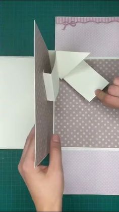 someone cutting out some paper with scissors on a piece of paper that is folded in half