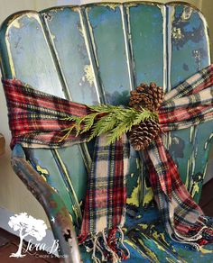 an old chair with a pine cone and plaid scarf tied around the armrests