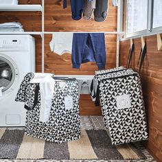 two laundry bags sitting next to each other in front of a washer and dryer