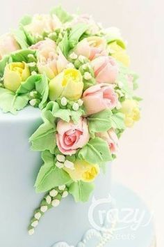 there is a cake with flowers on the top and bottom layer, decorated in pastel colors