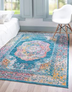 a blue area rug with an ornate medallion design on the center in front of a window