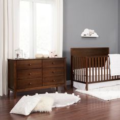 a baby crib and dresser in a room