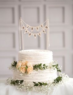 a white wedding cake decorated with flowers and bunting