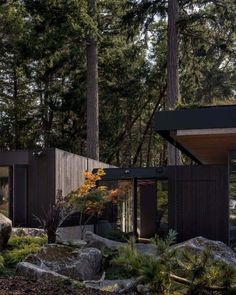 a house in the woods surrounded by rocks and trees