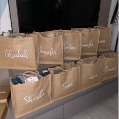 several bags with names on them are sitting in front of a television screen and there is no image here to describe