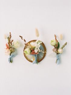 three boutonnieres with dried flowers on them are arranged next to each other