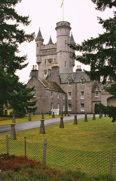 an old castle with trees and grass around it