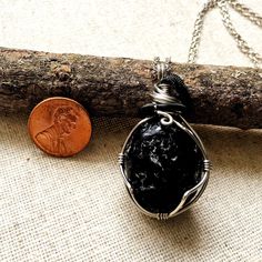 Experience bold protection and grounding when you wear this raw obsidian pendant. The men's stone necklace has a versatile design that you can easily wear it with any outfit. You customize this piece by choosing the material for its 24" chain or cord. The stone is a raw apache tear obsidian in hypoallergenic setting You choose your 24-inch chain from 18k white gold plated brass, black gunmetal, black flat leather, or black round cotton Pendant height is 2.0 Inches, width is 1.0 Inches Option to Spiritual Black Necklace With Raw Stone, Black Agate Crystal Necklace For Healing, Healing Black Agate Crystal Necklaces, Black Agate Wire Wrapped Jewelry, Spiritual Black Jewelry With Large Stone, Black Wire Wrapped Spiritual Crystal Necklace, Raw Obsidian, Apache Tears, Obsidian Crystal