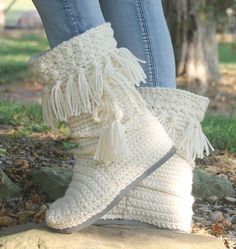 a woman's legs wearing white crocheted boots with fringes on them