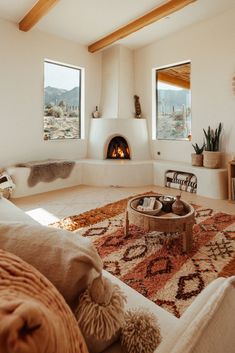 a living room filled with furniture and a fire place in the middle of the room