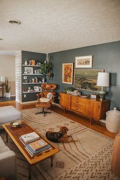 a living room filled with furniture and a dog laying on top of a rug in front of a coffee table