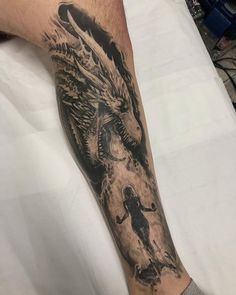 a man's leg with a dragon tattoo on it and a dog running behind him