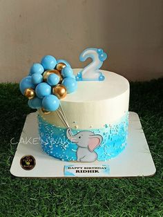 a birthday cake with blue and gold balloons