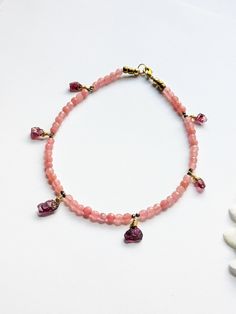 This bohemian anklet features: ~ Raw Garnets that acts as charms/tassels ~ Faceted Pink Crystal beads ~ Micro faceted Pyrites ~ Metallic gold Czech beads ~ Raw Brass Lobster clasp and Jump Ring ~ It is 10.5 inches wide. Thanks for shopping with JewelryByOri! Bohemian Pink Anklets With Round Beads, Pink Beaded Bohemian Anklets, Pink Bohemian Beaded Anklets, Adjustable Pink Bohemian Anklets, Handmade Adjustable Dangle Anklets, Raw Garnet, Bracelet Summer, Summer Body, Ankle Bracelet