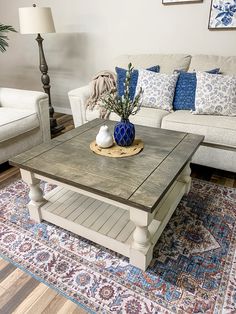 a living room with couches and a coffee table in the middle on a rug