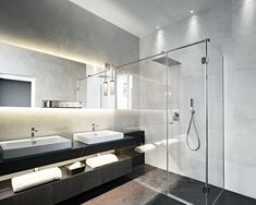 a bathroom with two sinks and a walk in shower next to a large mirror on the wall