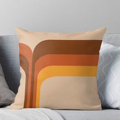 a throw pillow with an abstract design on the front and back of it, sitting on top of a couch