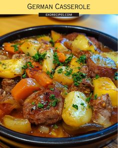 german casserole with potatoes and meat in a black bowl on a wooden table