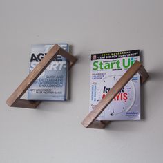 two pieces of wood sitting on top of a wall next to each other with magazines