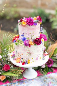 three white cakes with flowers on them sitting in a barrel