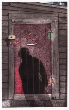 the shadow of a person standing in front of a wooden building with a red light