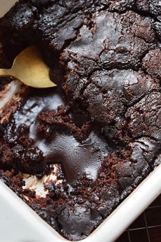 a chocolate cake in a blue and white bowl with a spoon sticking out of it