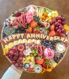 a person holding a platter of food with the words happy anniversary written on it