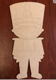 paper cut out of a cartoon character on a wooden floor with text overlay that says,