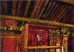 an old photo of a room with wooden floors and walls, including a red cabinet in the center