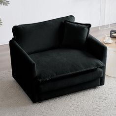 a black chair sitting on top of a white rug