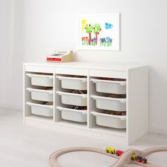 a toy train set sitting on top of a white shelf next to a play area