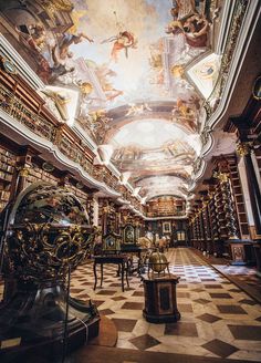 an ornate library with many bookshelves and paintings on the ceiling