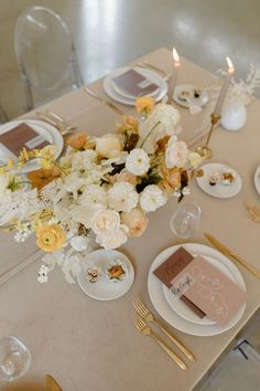 the table is set with white and yellow flowers