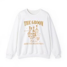 a white sweatshirt that says the groon on it with bottles in gold lettering