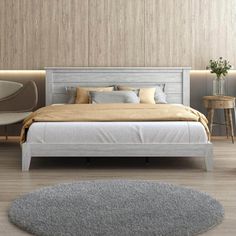 a white bed sitting in a bedroom on top of a hard wood floor next to a table