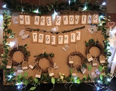 a bulletin board with words that spell out we are growing together surrounded by wreaths and lights