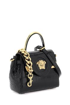 La Medusa handbag by Versace crafted in croco-embossed leather, featuring flap with magnetic button closure and the iconic metal Medusa head. Single handle with gold metal detail, removable chain shoulder strap and removable and adjustable crossbody shoulder strap in leather. Side straps, leather interior with an open flat pocket. Versace Gold finished metalware. Size Info STANDARD Color Detail Black Made In Italia Material 100% calf leather Season One spring Season Two summer Product bags Brand Evening Crossbody Flap Bag With Gold-tone Logo, Designer Top Handle Bag With Gold-tone Logo Plaque, Formal Bags With Gold-tone Logo Plaque And Top Handle, Formal Bags With Top Handle And Gold-tone Logo Plaque, Formal Top Handle Shoulder Bag With Gold-tone Logo, Luxury Crossbody Flap Bag With Gold-tone Logo, Evening Top Handle Bag With Gold-tone Logo, Designer Top Handle Shoulder Bag With Metal Logo, Designer Shoulder Bag With Top Handle And Metal Logo