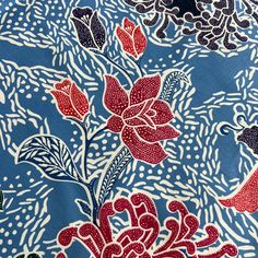 a blue and red floral print fabric with white dots on the bottom half of it